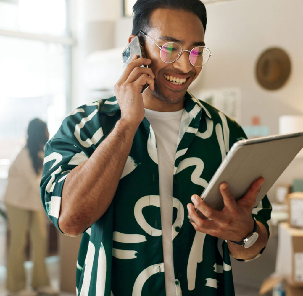 Man working on tablet and making a call