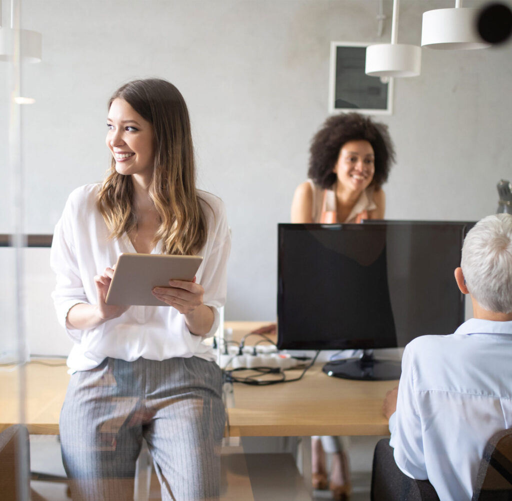 Women working in office on tablet and desktop